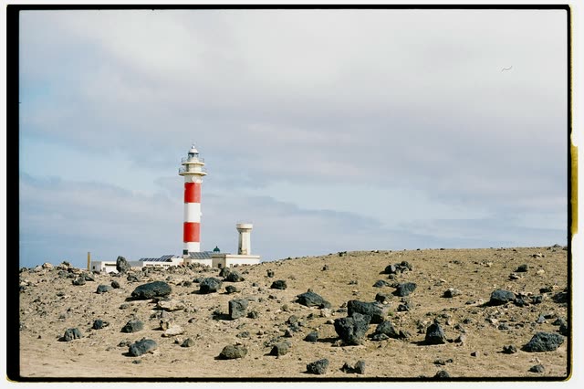 Scout photo on the moodboard: a red and white lighthouse on a stony coast